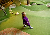 Tjej går över äventyrsgolf fairway