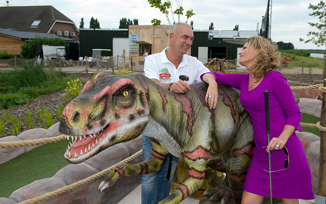 Couple with putters and a dinosaur at adventure golf